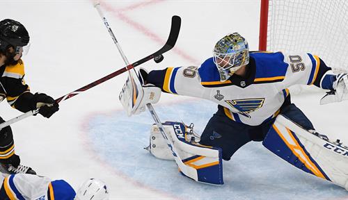 Photo shows a moment in game seven of the National Hockey League’s Stanley Cup Finals between the St. Louis Blues and the Boston Bruins. Blues goalie Jordan Binnington blocks a shot as the Bruins’ Marcus Johansson looks for the rebound.