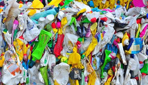 Photo shows a bale of plastic polyethylene bottles crunched into a bale and awaiting recycling.